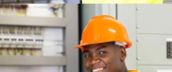 electrician in a safety helmet with an electrical setting in the background.